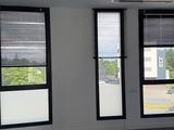 une pièce dotée de trois fenêtres et d'un ventilateur de plafond