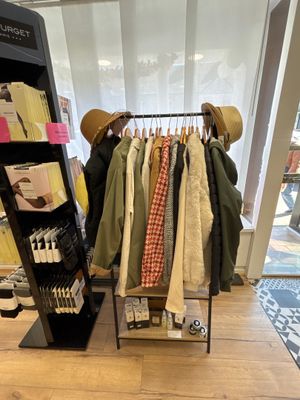 un présentoir de vêtements et de chapeaux sur un portemanteau dans un magasin