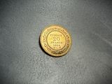 a close up of a gold coin on a gray surface