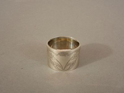 une bague en argent ornée d'un motif, posée sur une table