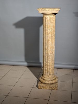 un socle en marbre surmonté d'une horloge, placé au milieu d'une pièce
