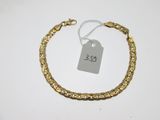 gros plan d'un bracelet en or portant une étiquette de prix