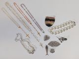 de nombreux colliers et bracelets disposés sur une surface blanche