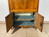 a wooden cabinet with a door open on a tiled floor