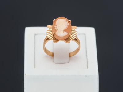 a close up of a gold ring with a face on it