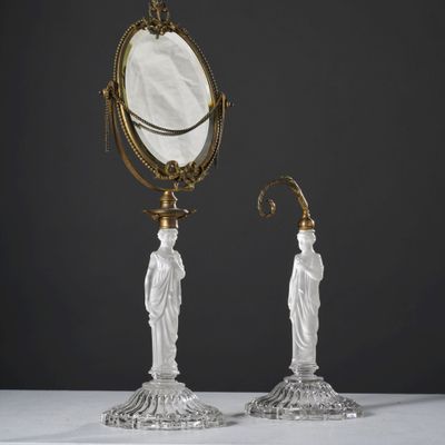 une paire de bougeoirs anciens en verre, accompagnés d'un miroir et d'une statuette