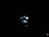 a close up of a blue diamond on a black surface