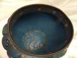 a blue bowl sitting on top of a white sheet