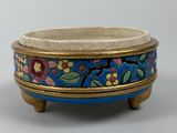 a close up of a small blue bowl with flowers on it