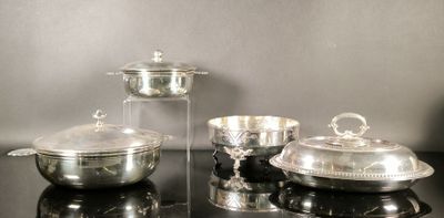 trois plats en argent posés sur une table noire recouverte d'un couvercle en verre