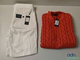 deux paires de pantalons blancs et un pull rouge posés sur une table