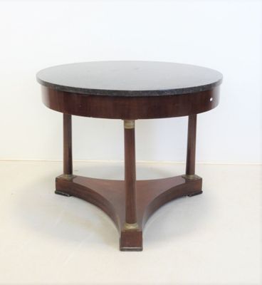 une table ronde avec un plateau noir et un piètement en bois