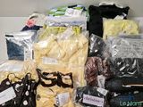 de nombreux sacs contenant des vêtements et d'autres objets posés sur une table