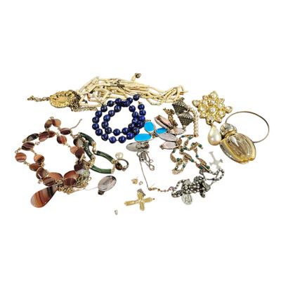 a pile of assorted bracelets and necklaces on a white surface