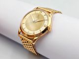 a gold watch sitting on top of a napkin