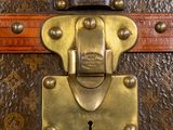 a close up of a metal lock on a brown suitcase