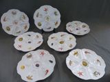 six assiettes blanches ornées de motifs différents, posées sur une table