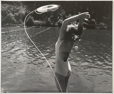 photographie en noir et blanc d'une femme en maillot de bain tenant un frisbee