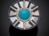 une bague blanche et bleue sertie d'une pierre turquoise entourée de diamants bleus et blancs