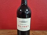 La bouteille de vin est posée sur la table, devant un mur rouge.