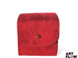 a red case with a button on it on a white surface