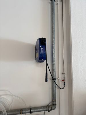 a water heater on the wall next to a pipe