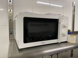 un micro-ondes blanc posé sur un plan de travail dans une cuisine