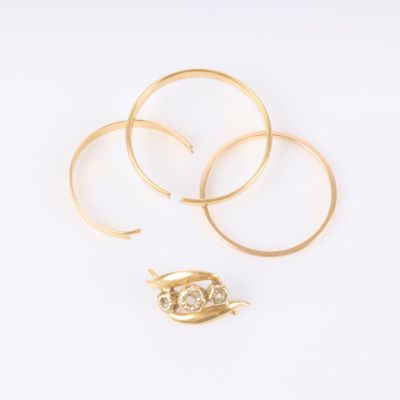 un ensemble composé de trois bagues en or et d'une broche en feuille d'or