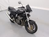 a black motorcycle parked in a room with a white wall
