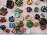 many different buttons and buttons on a pink surface
