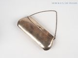 a silver purse that is sitting on a white surface