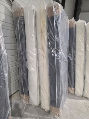 de nombreux matelas emballés dans du plastique dans un entrepôt