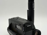 a black camera and a mouse on a white surface