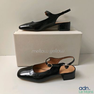les chaussures noires sont posées sur la boîte, à côté de celle-ci