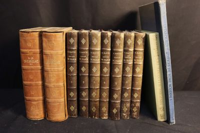 Plusieurs livres anciens sont alignés sur un fond noir.