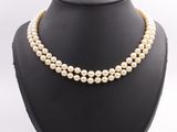 a three strand pearl necklace on a mannequin display