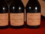 three bottles of wine are lined up on a red table