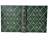 an old book with a green cover and gold designs on it