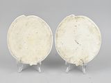 pair of white plates on stands on a gray surface