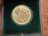 a gold medal in a black box on a table