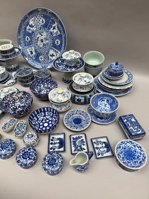 de nombreuses assiettes et bols bleus et blancs sur la table
