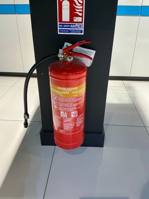 un extincteur posé par terre à côté d'une borne d'incendie