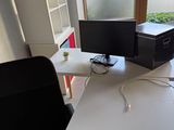 a desk with a computer monitor and a printer on it