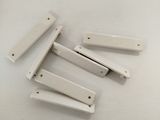 four pieces of white plastic hair clips on a white surface