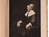 an old black and white photo of a woman sitting in a chair
