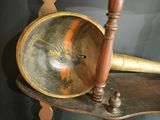 a wooden table with a brass plate and a brass horn on it