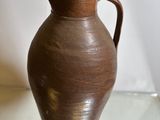 a brown vase that is sitting on a glass table