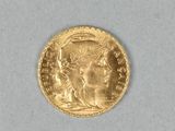 gros plan d'une pièce d'or sur une surface blanche