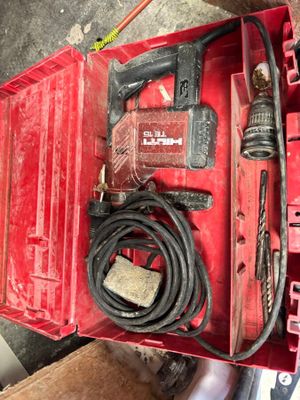 une boîte à outils rouge contenant une perceuse et d'autres outils
