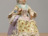 a figurine of a woman sitting on a table